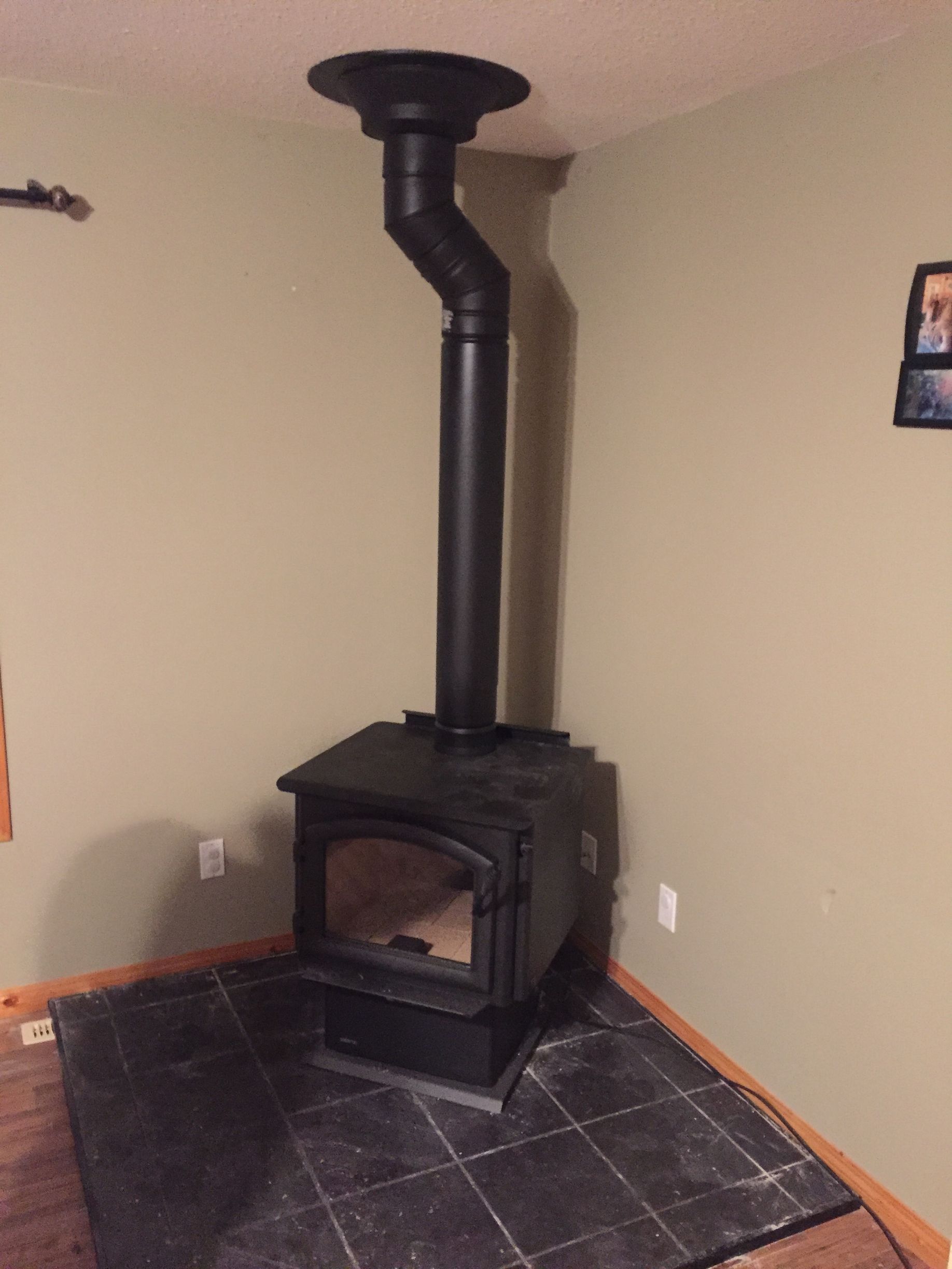 A black wood stove in a corner of a room
