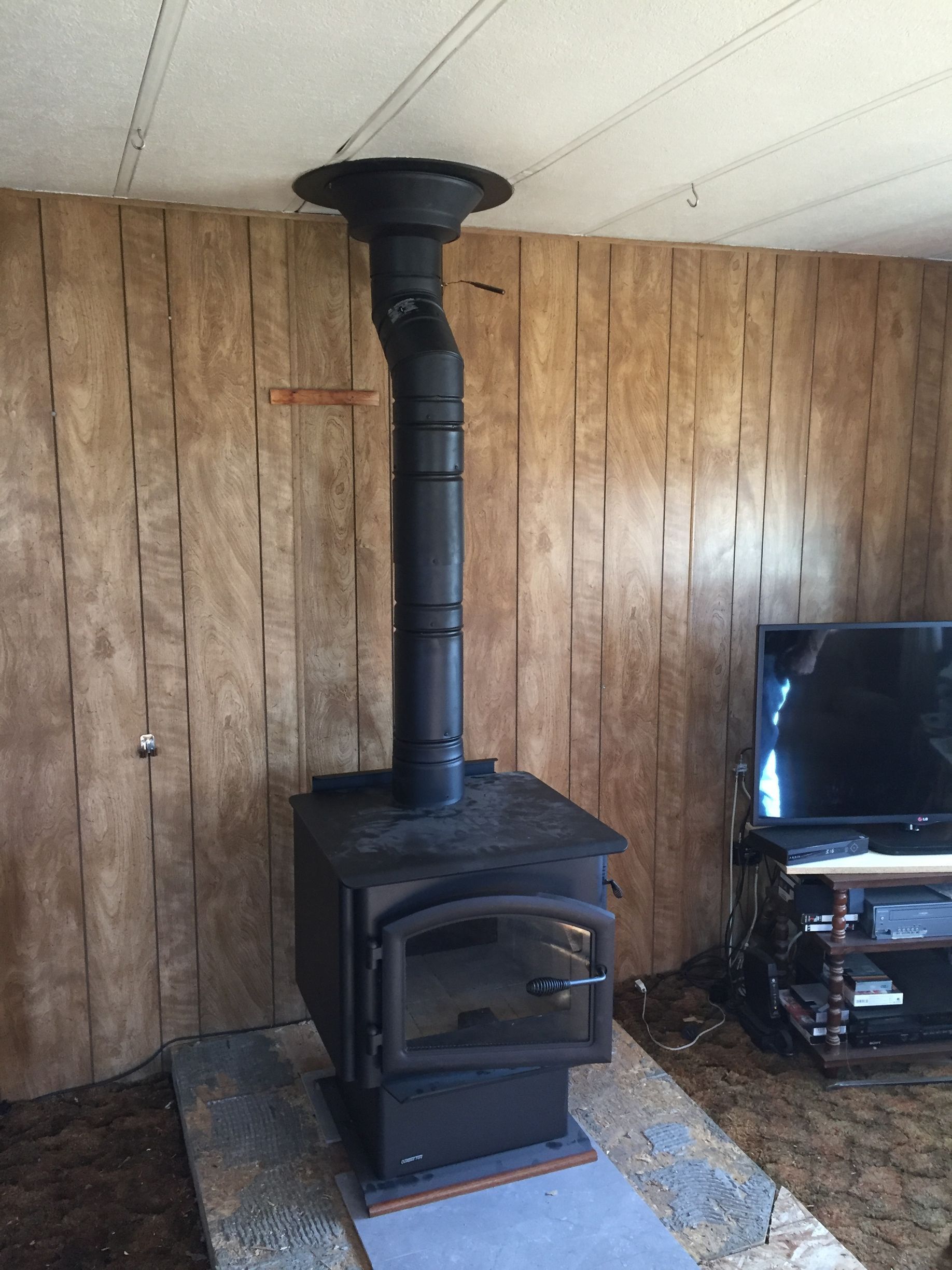 A wood stove is sitting in a living room next to a television.