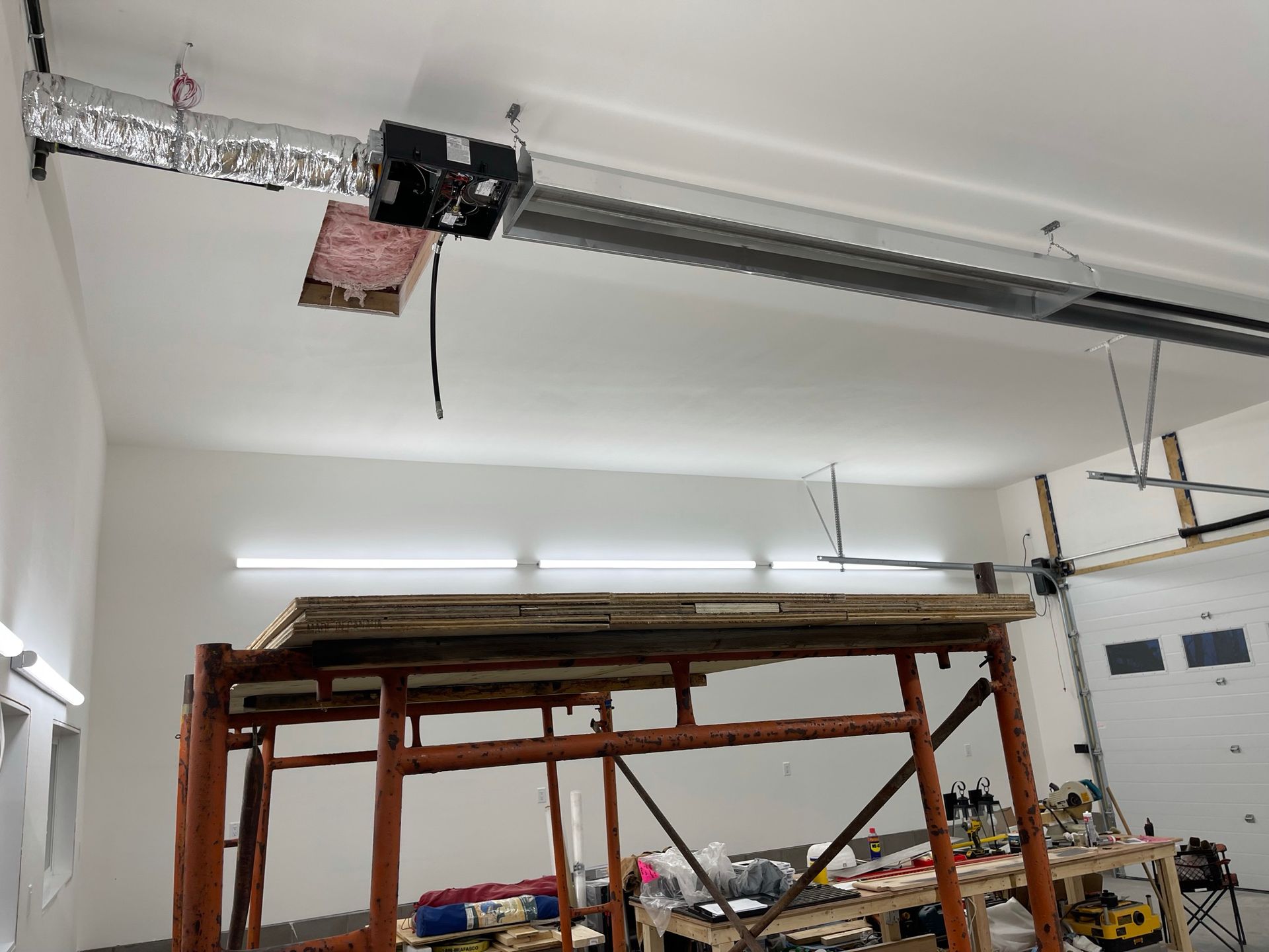 A garage with a scaffolding and a garage door opener.