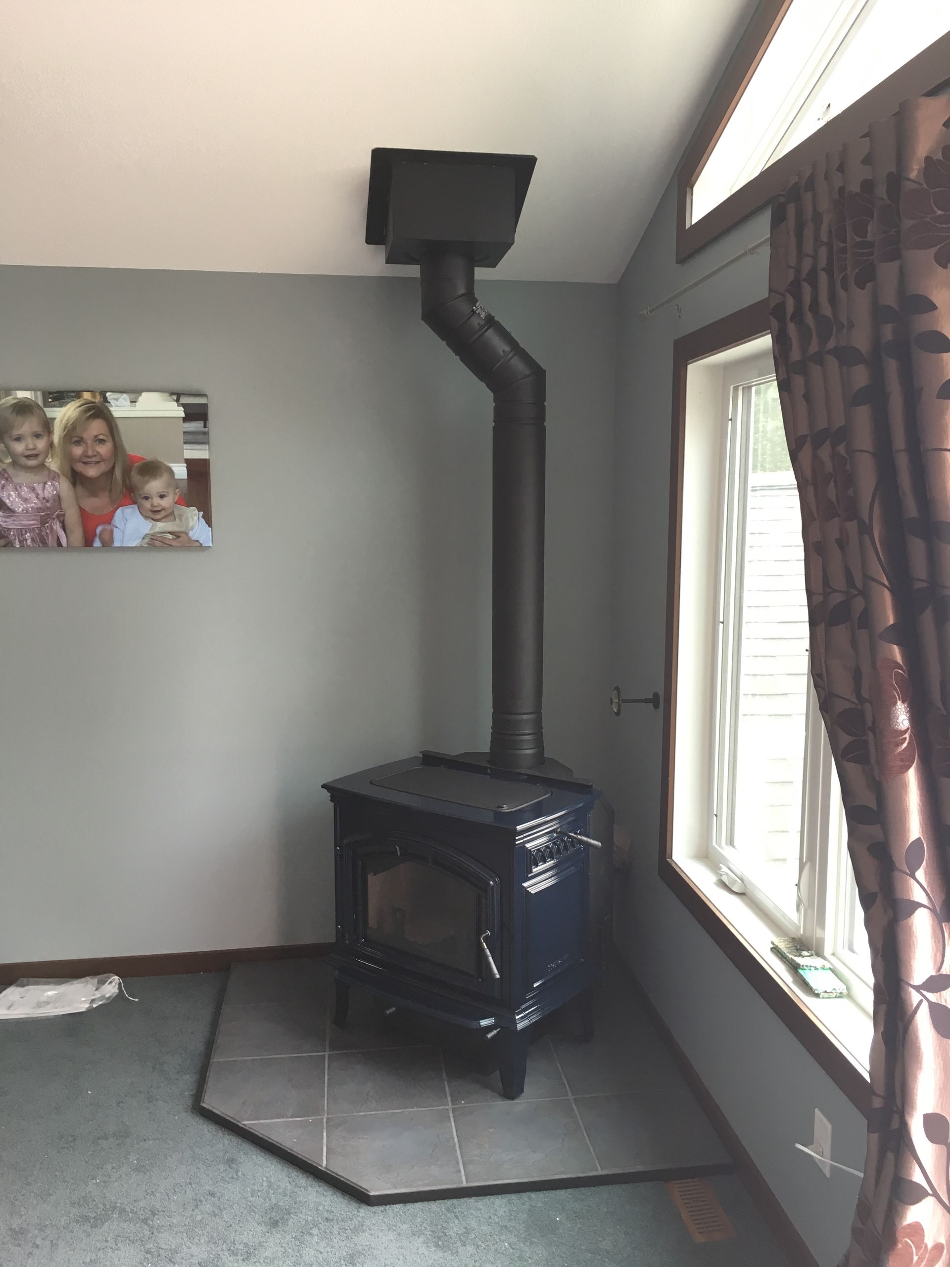 A room with a wood stove and a picture on the wall above it