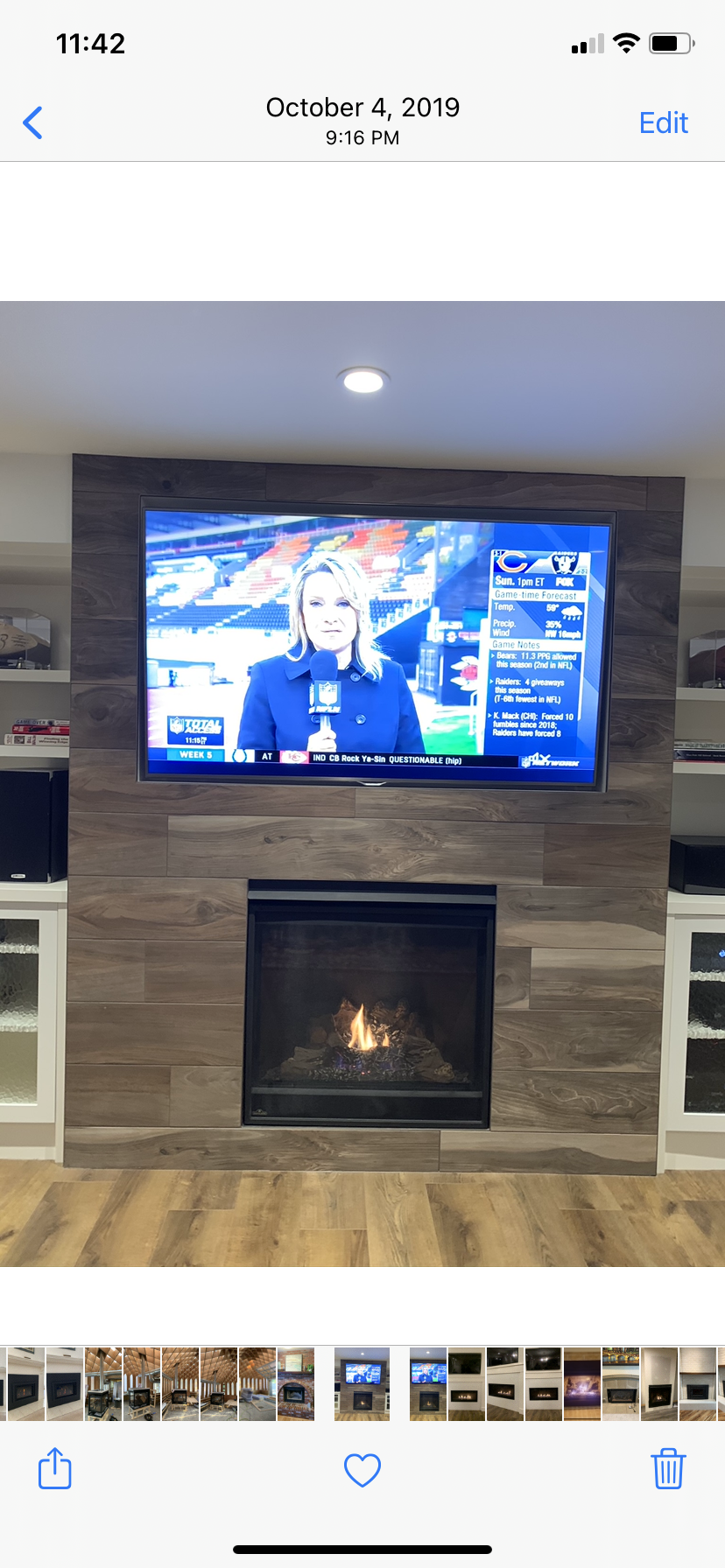 A living room with a fireplace and a flat screen tv on the wall.