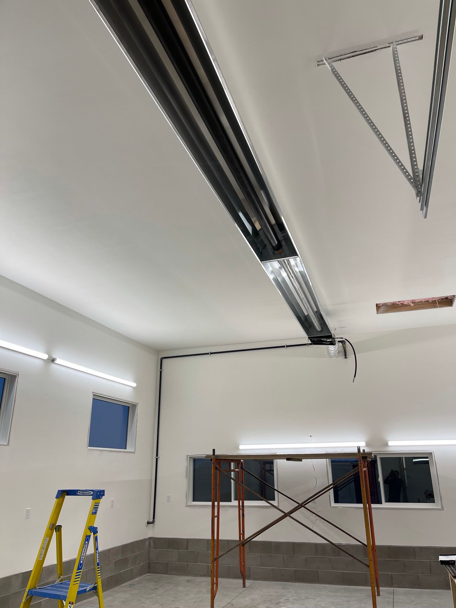 A garage with a ladder and a chain hanging from the ceiling.