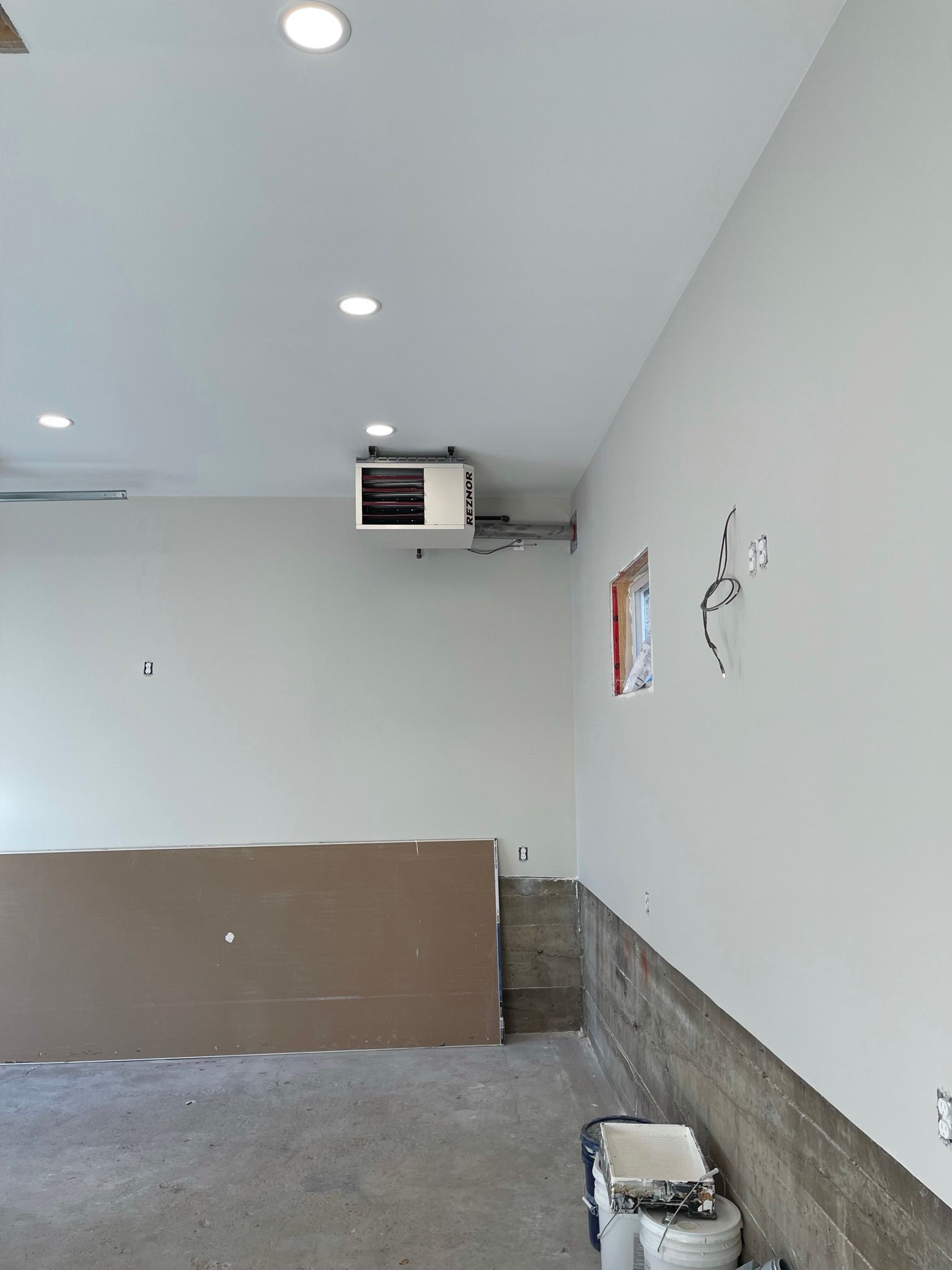 A garage with a heater hanging from the ceiling.