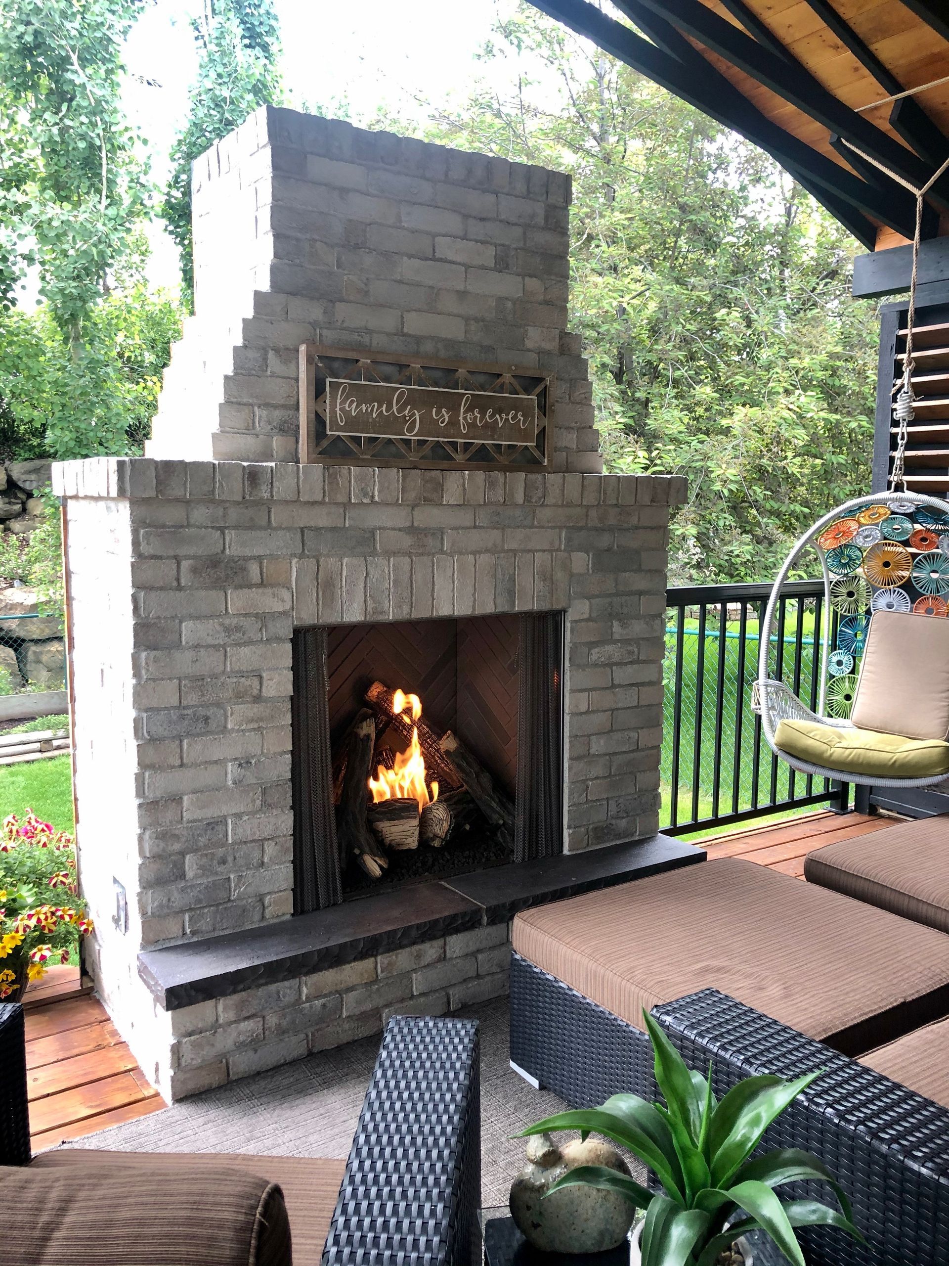 A brick fireplace is sitting on top of a wooden deck.