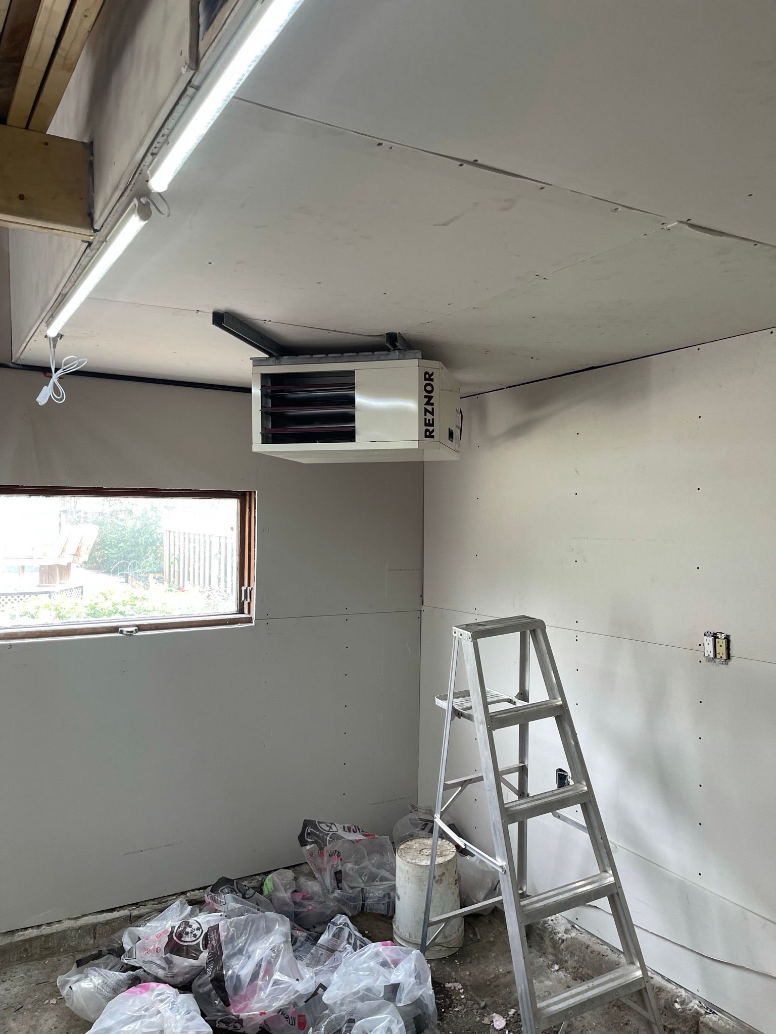 A room with a ladder and a ceiling fan.