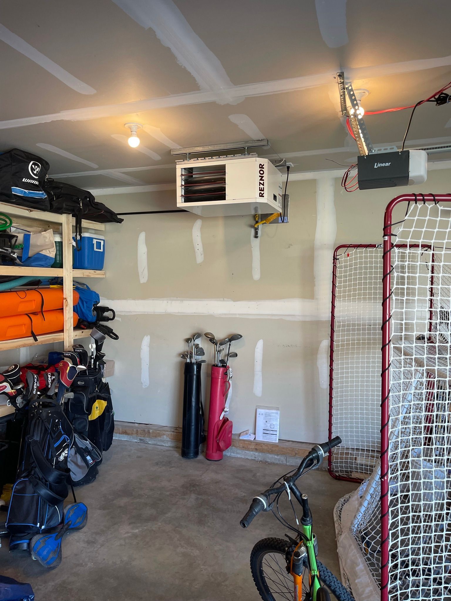 A garage with a bicycle and a hockey net.