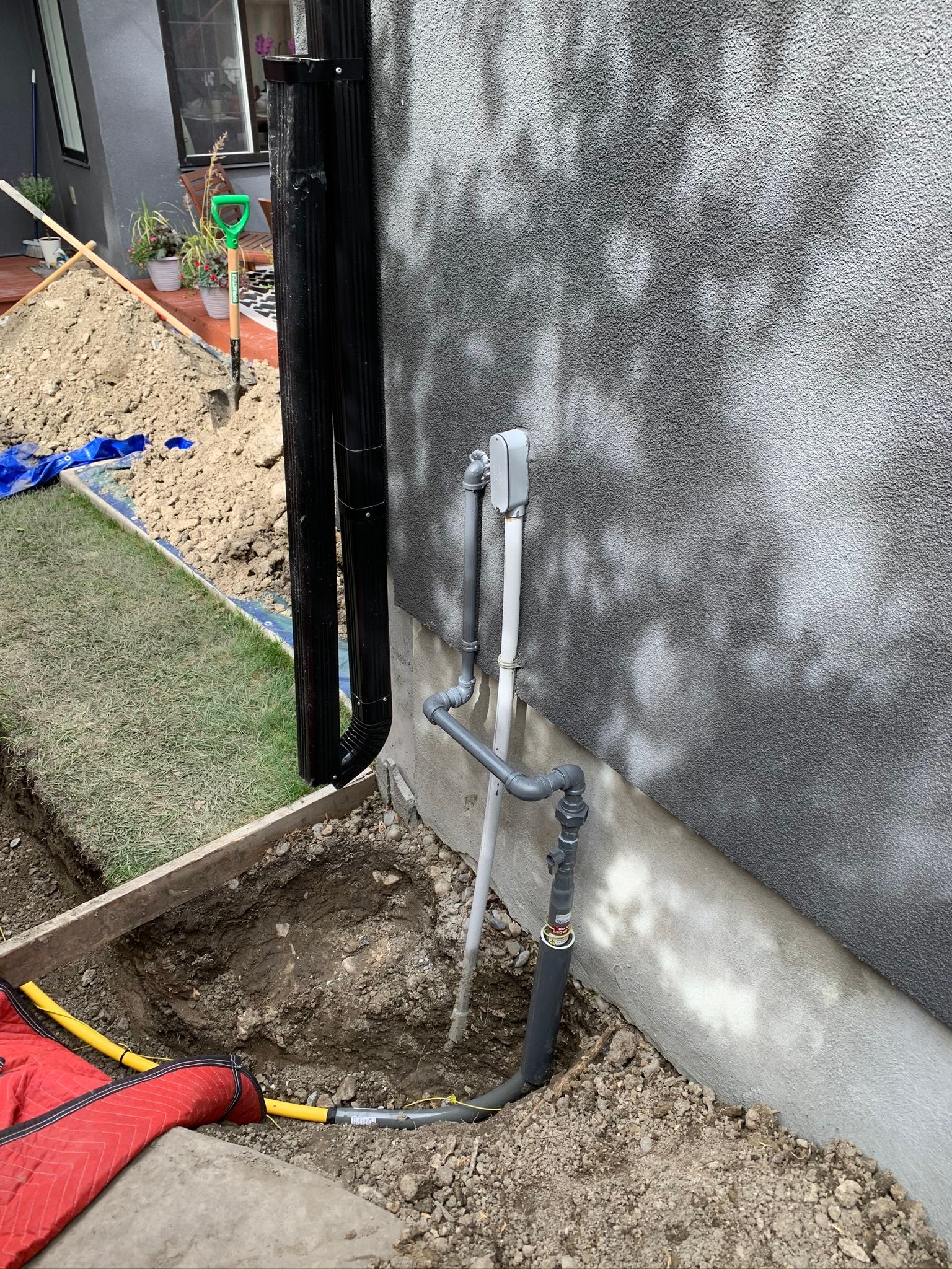 A pipe is being installed on the side of a building.