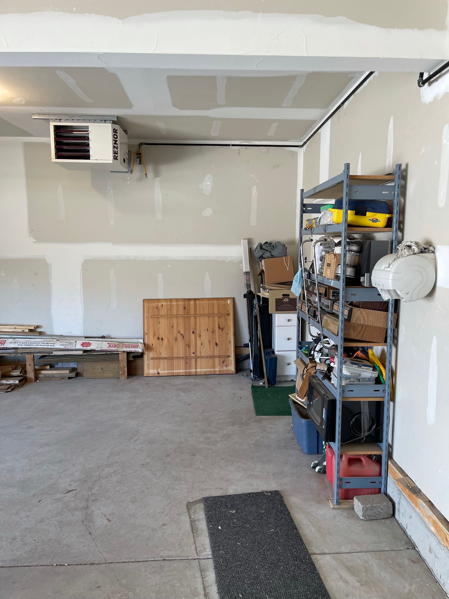 A garage with a lot of shelves and boxes on the floor.