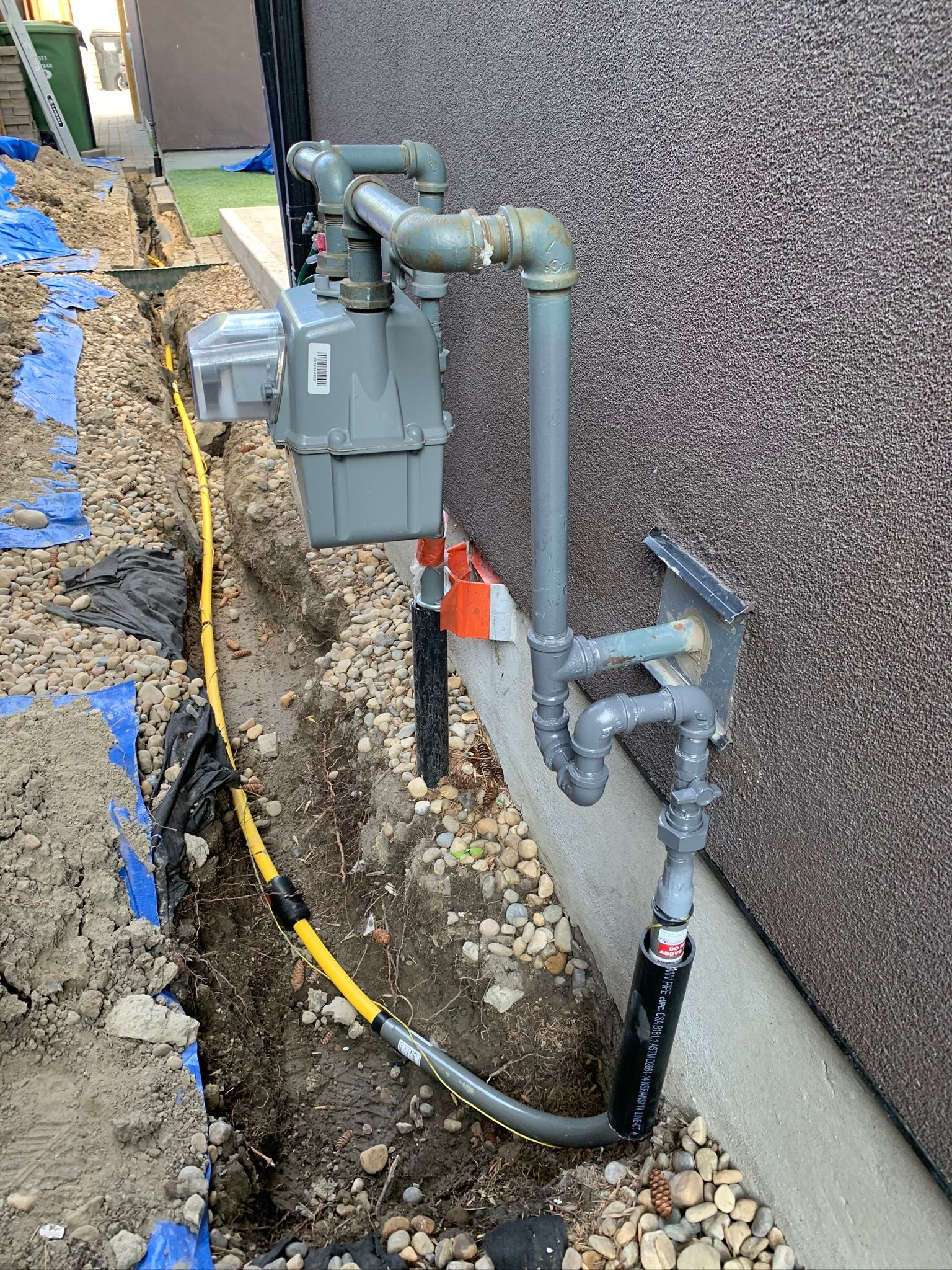 A gas meter is being installed on the side of a building.