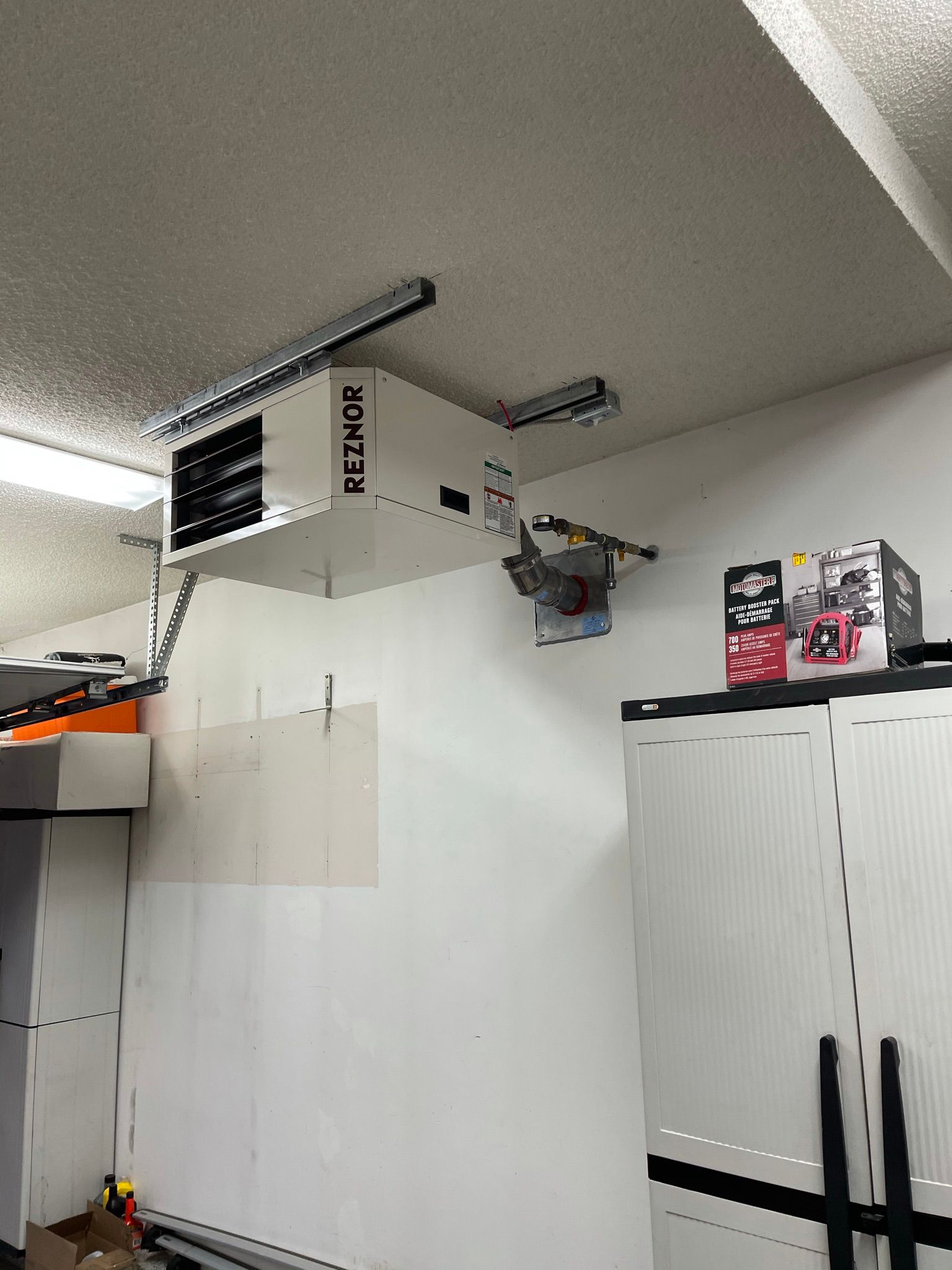 A garage with a garage door opener hanging from the ceiling.