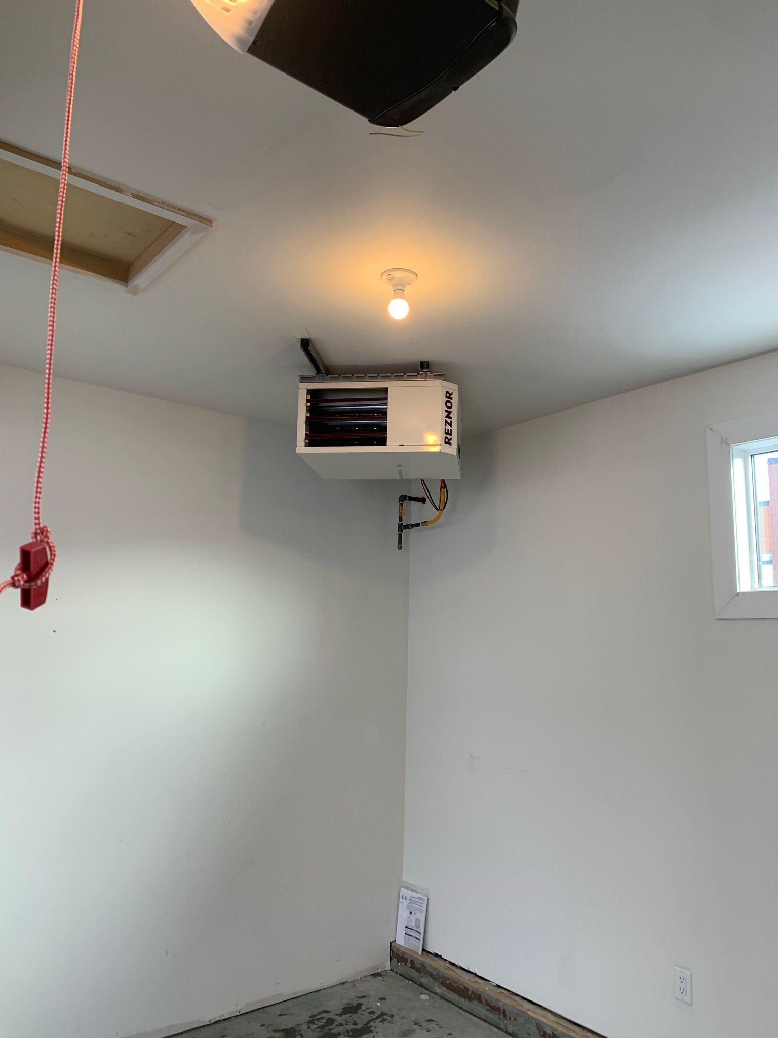 An empty room with a ceiling fan and a window.