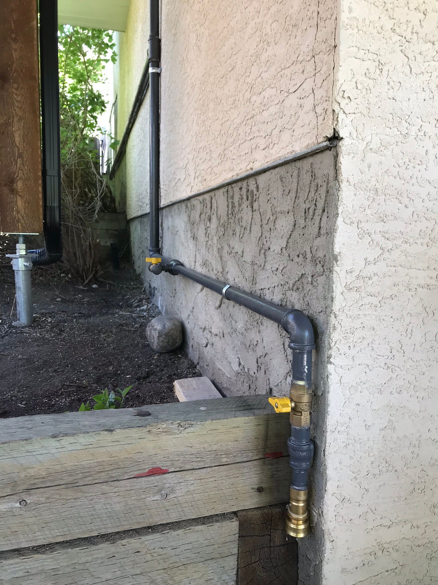 A pipe is attached to the side of a building.