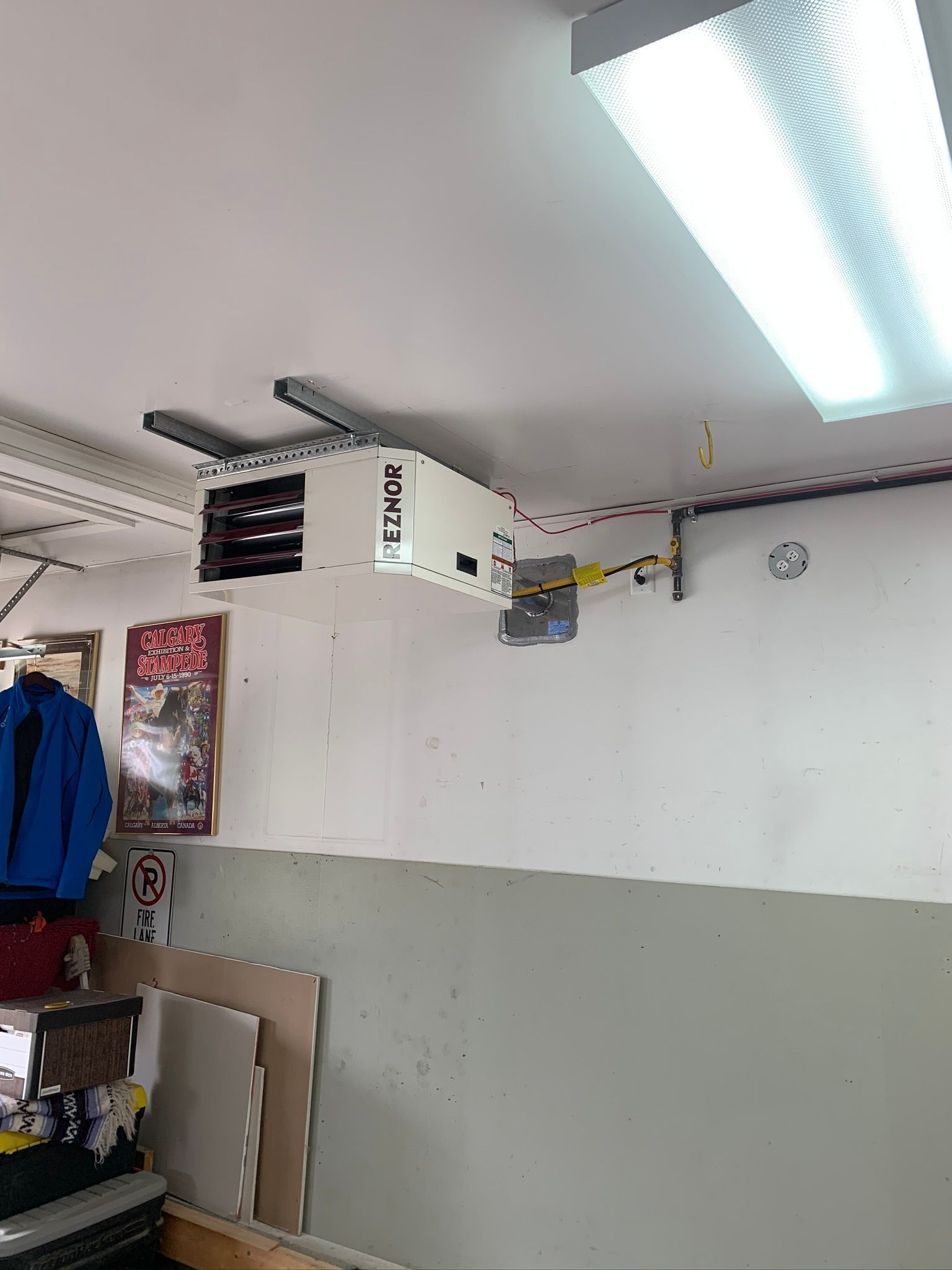 A garage with a heater hanging from the ceiling.