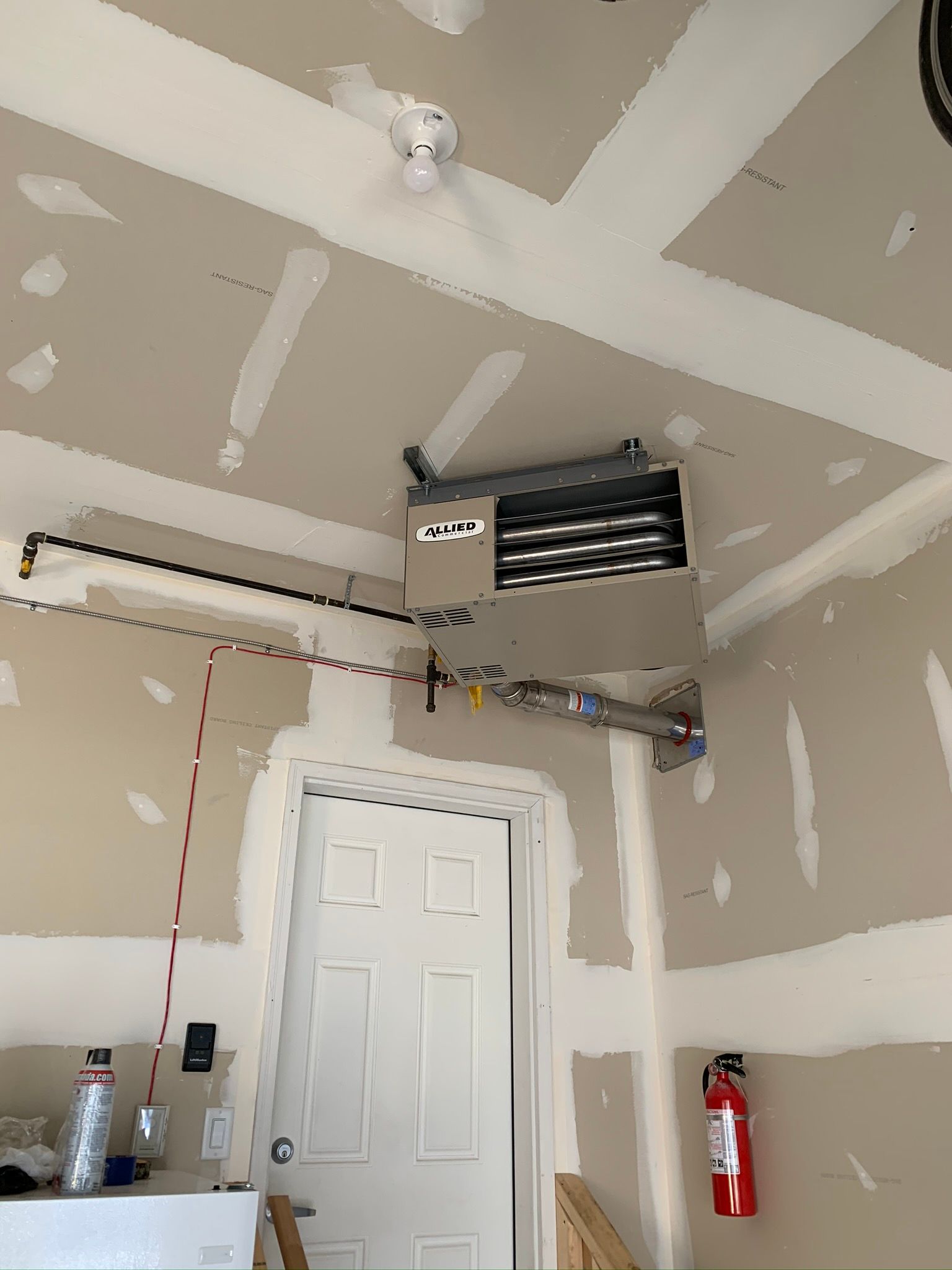 A garage with a door and a ceiling fan.