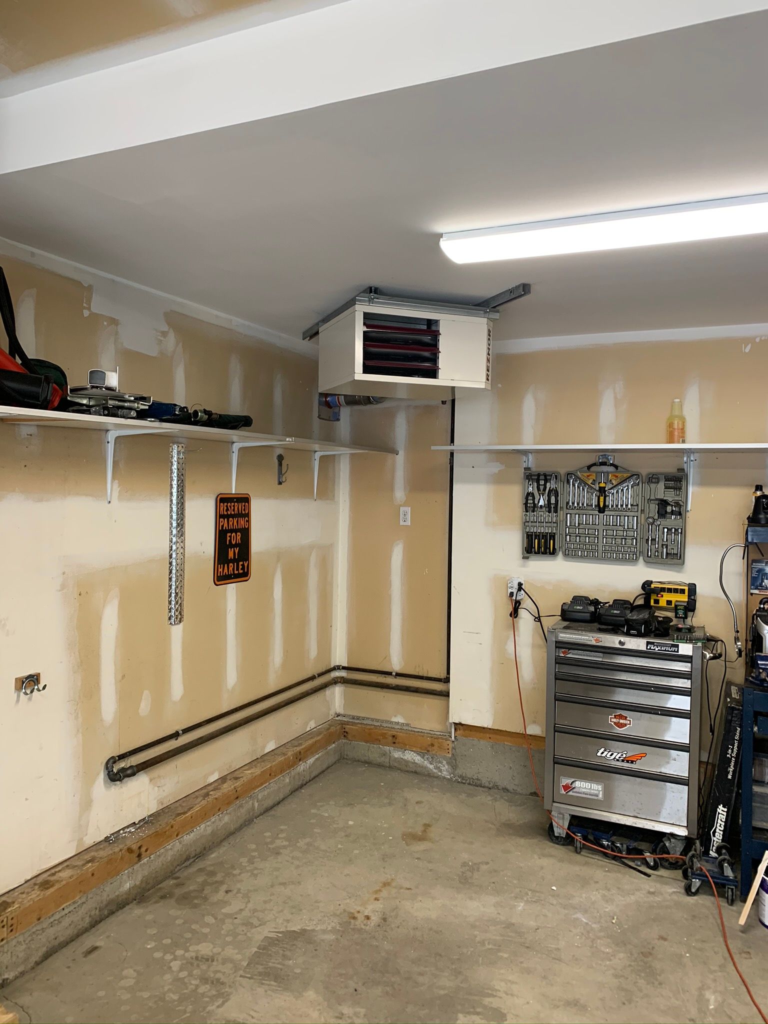 A garage with a lot of tools and a heater on the ceiling