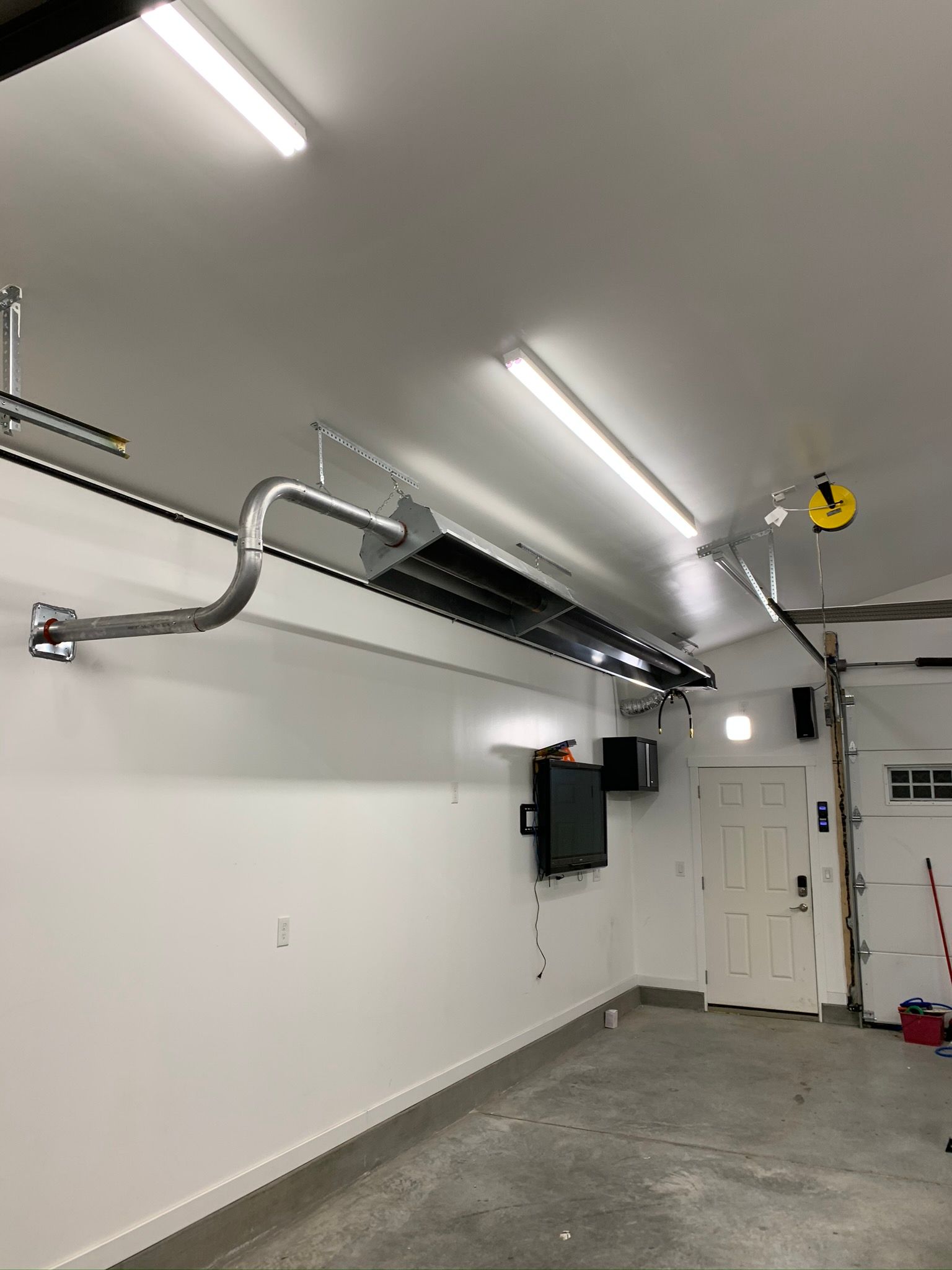 A garage with a ceiling fan and a tv on the wall.