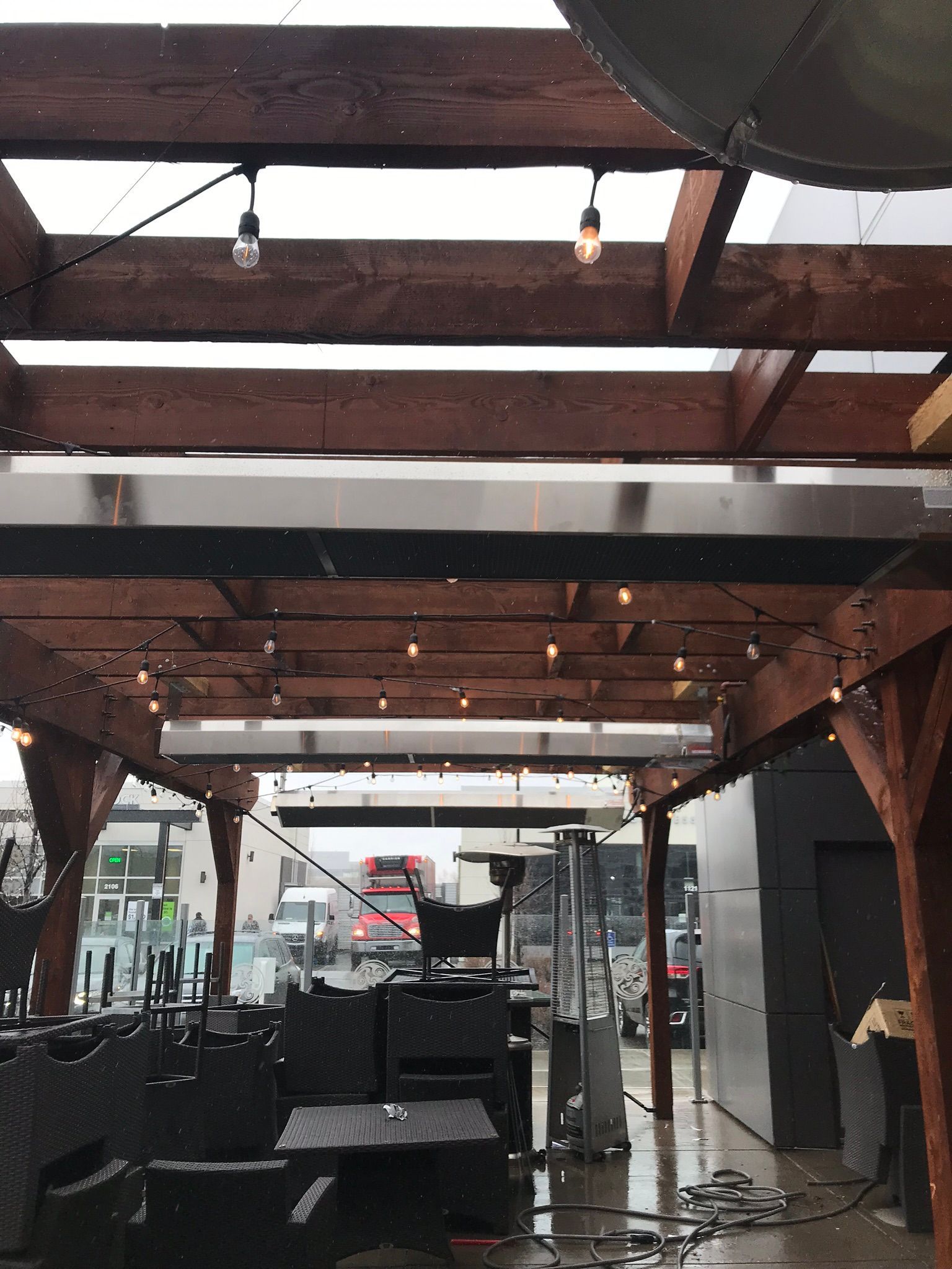 A wooden pergola with lights hanging from the ceiling.