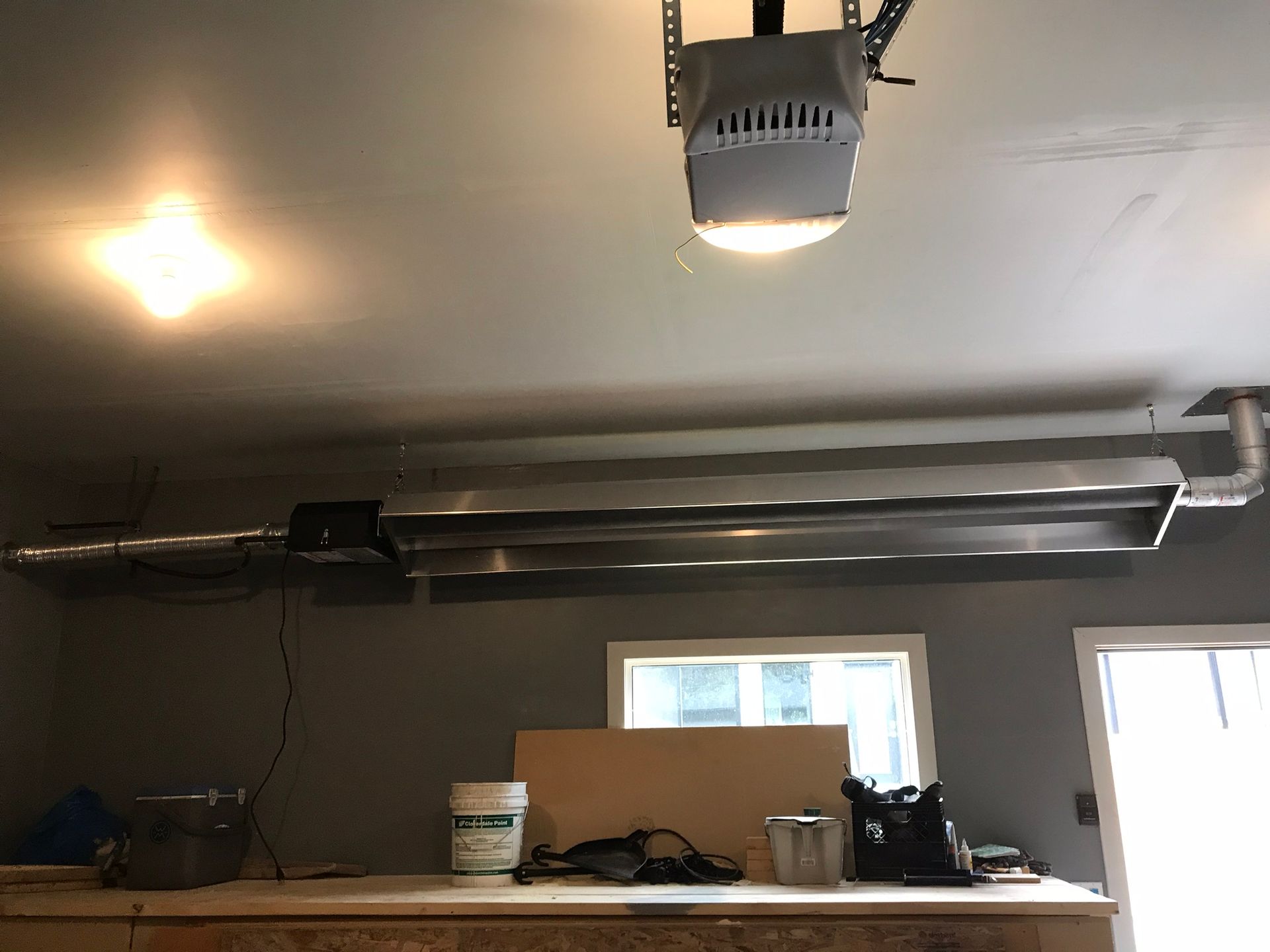 A garage door opener is hanging from the ceiling in a garage