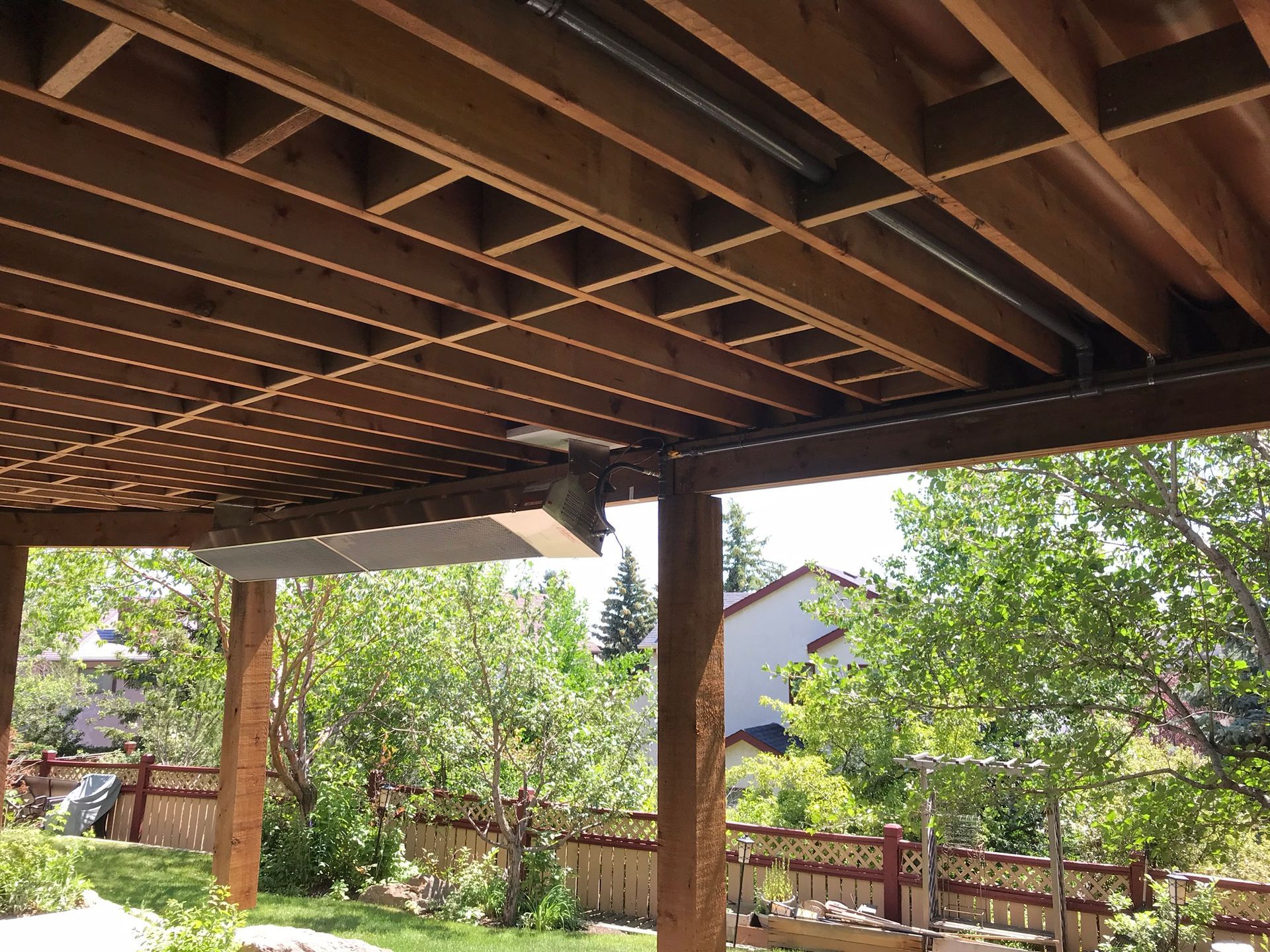 The ceiling of a wooden deck with trees in the background