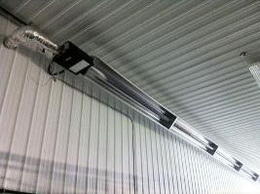 A long heater is hanging from the ceiling of a building.