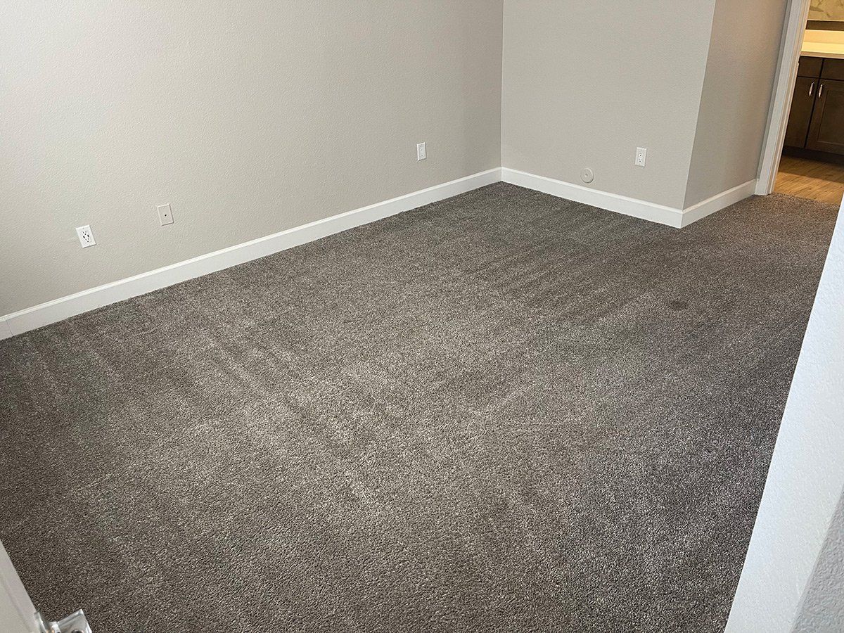 Empty room with gray carpet, beige walls, and white trim.