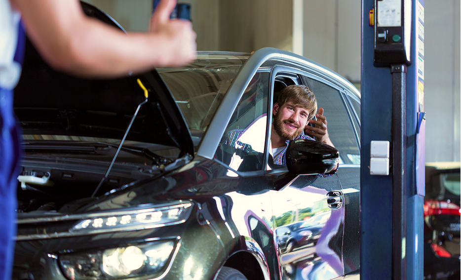 Man inside vehicle in garage discussing with technician | RTS Tire & Auto Repair