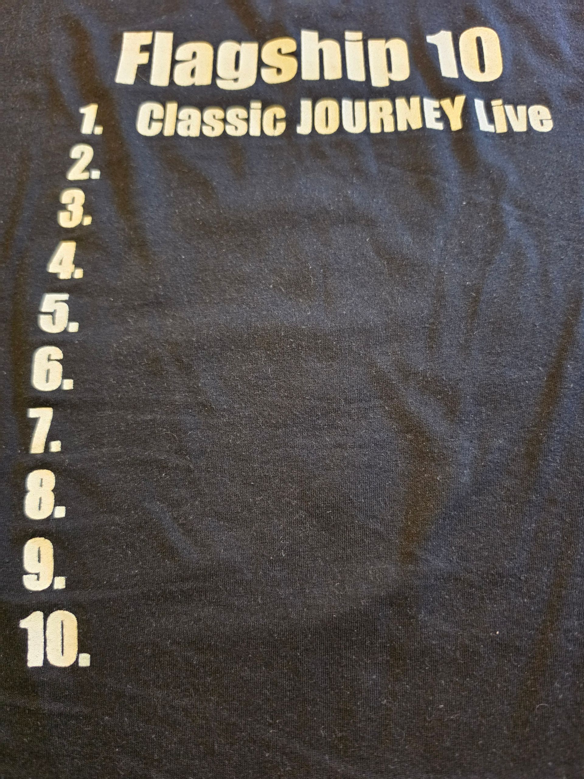 Black T-shirt with white text reading “Flagship 10” and “Classic JOUrNEY Live,” with a numbered list 1–10.