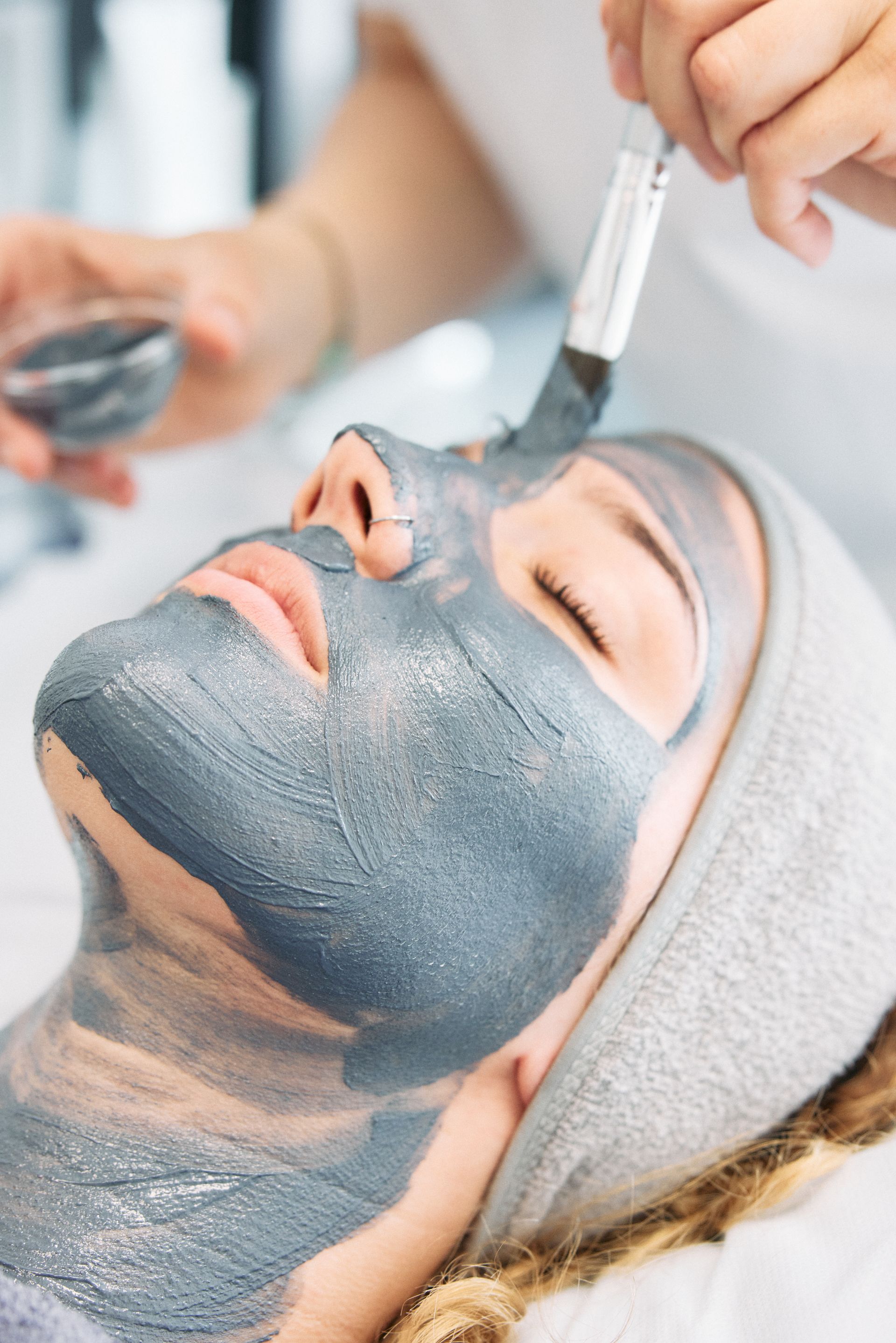 Eine Frau bekommt eine blaue Gesichtsmaske in einem Spa .