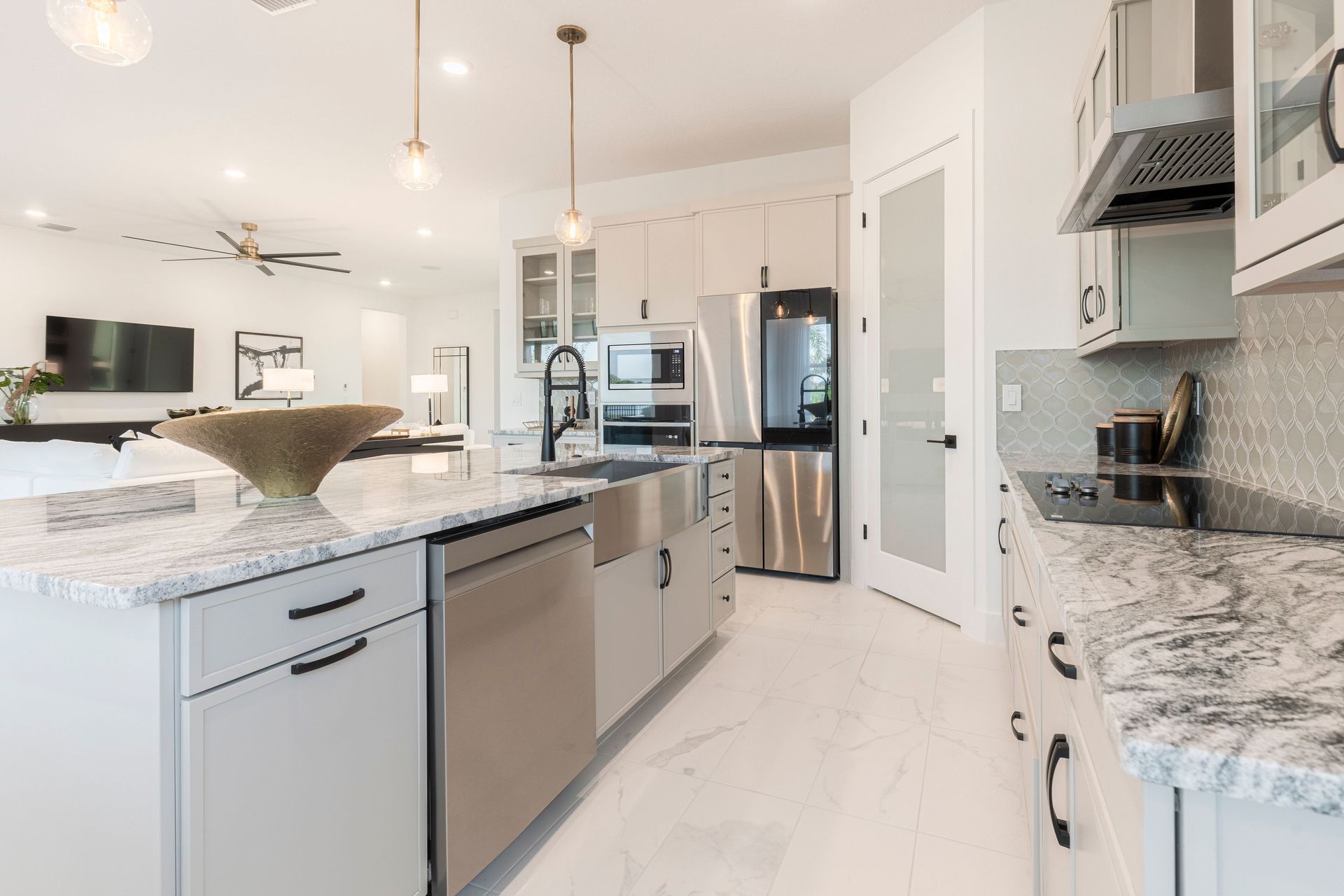Modern kitchen with stainless steel appliances, white cabinets, granite countertops, and island.