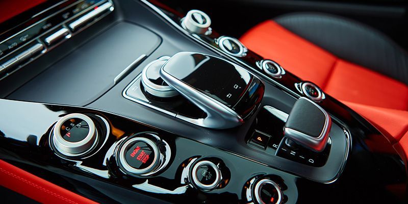 A close up of the dashboard of a car with red seats.