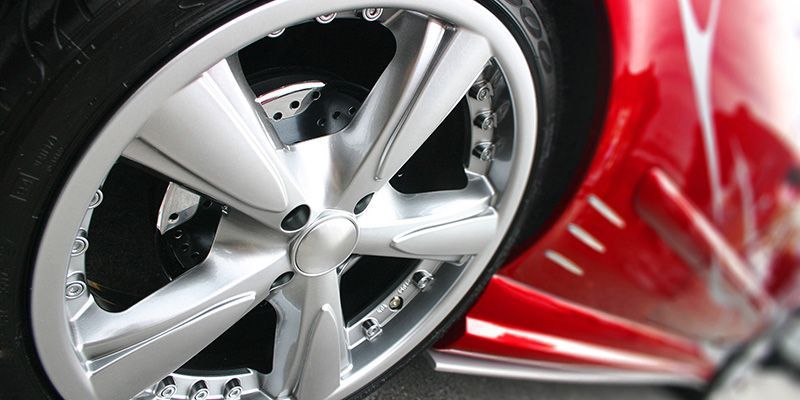 A close up of a car wheel on a red car