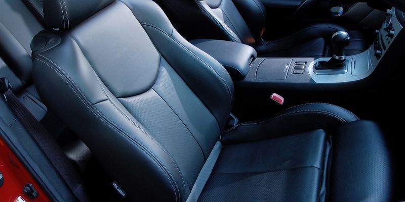 A red car with black leather seats and a shifter