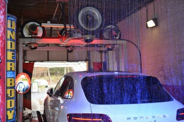 A white car is being washed in a car wash.