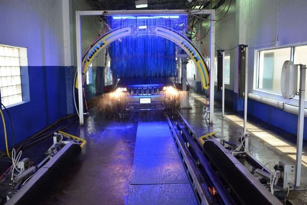 A car is going through a car wash with blue lights on.