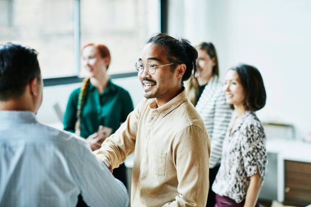 A group of people are shaking hands in an office.