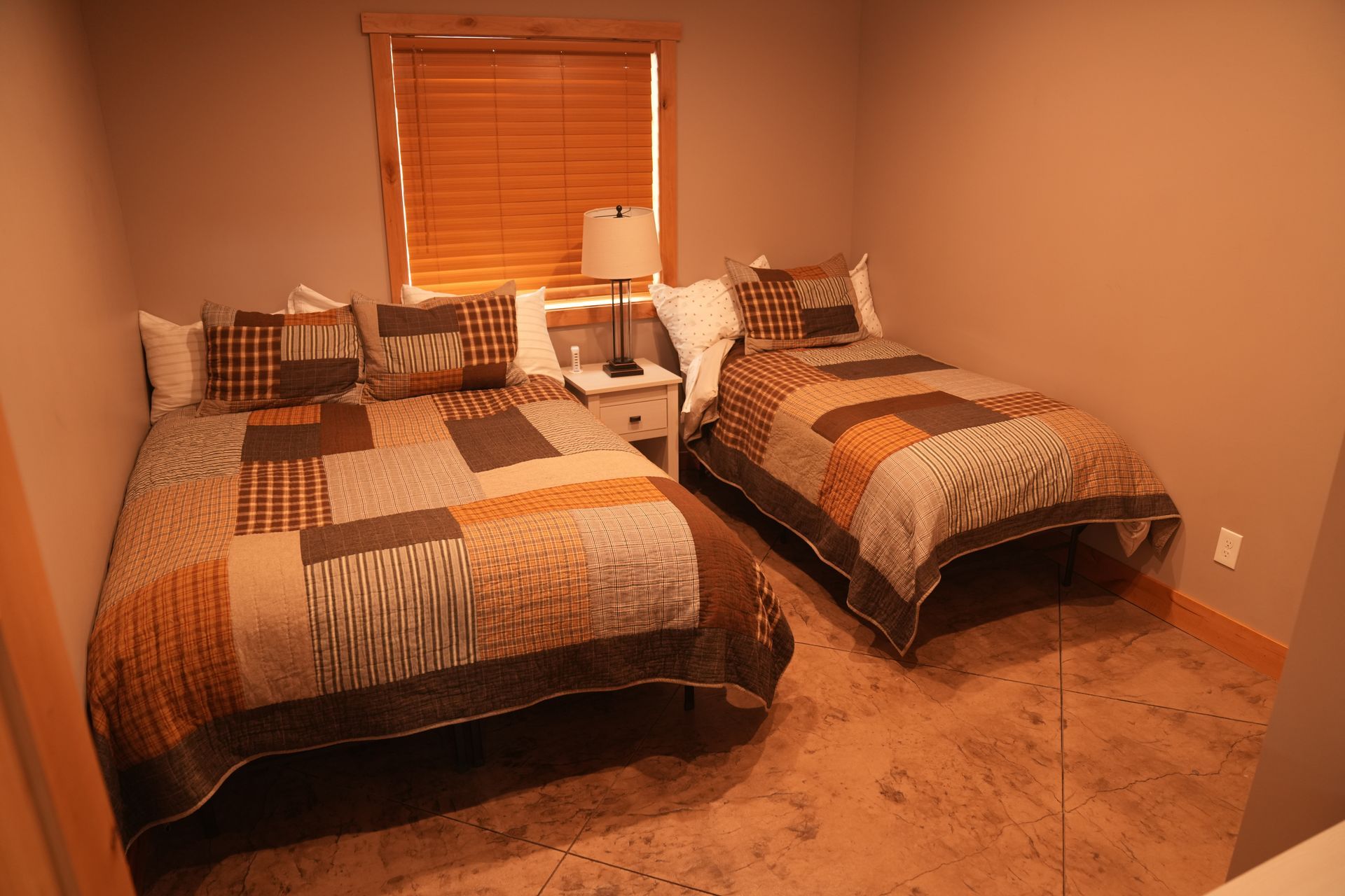 A bedroom with two beds and a window.