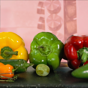 A variety of peppers including yellow green and red are on a table