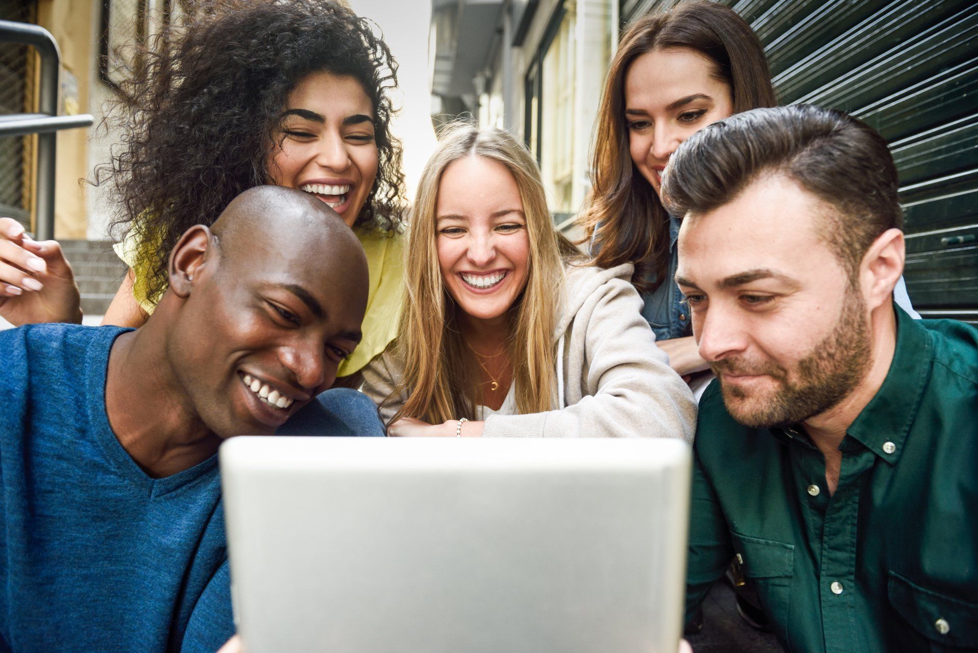 A group of people are looking at a laptop computer.