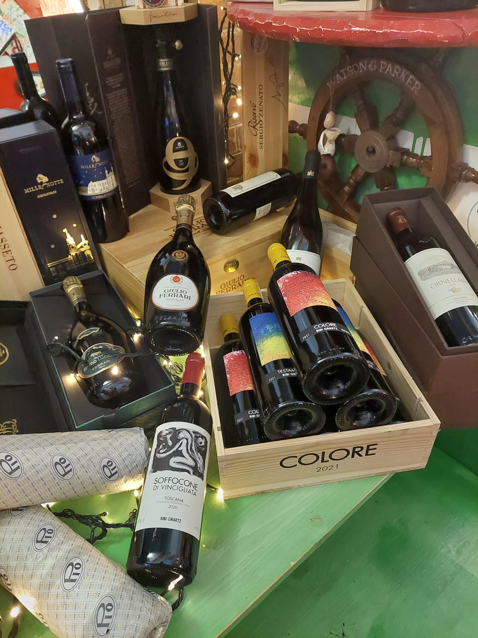 Un mucchio di bottiglie di vino sono appoggiate su un tavolo.