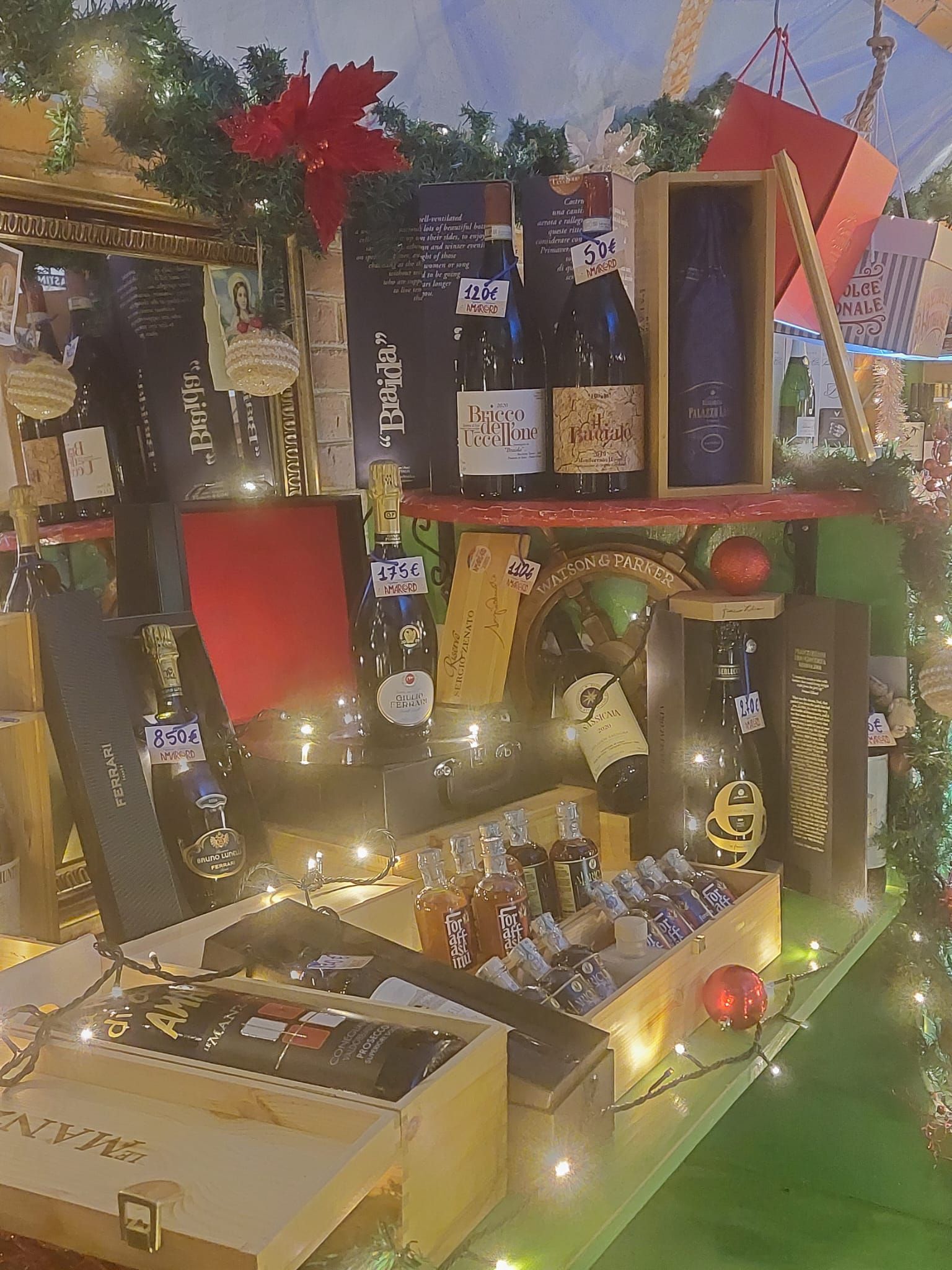 Un tavolo pieno di bottiglie di vino e decorazioni natalizie.