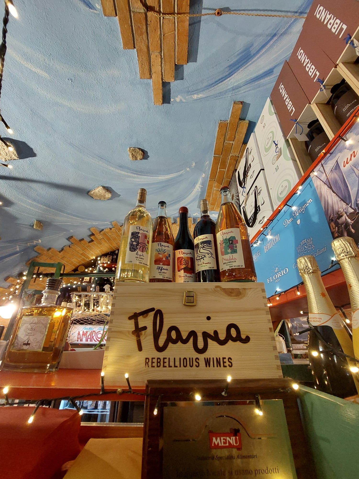 Una scatola di legno piena di bottiglie di vino è appoggiata su un tavolo in un ristorante.