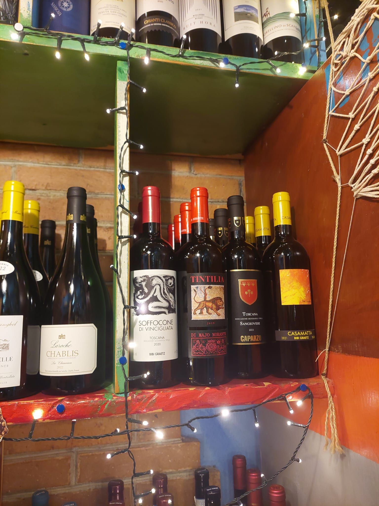 Diverse bottiglie di vino sono allineate su uno scaffale