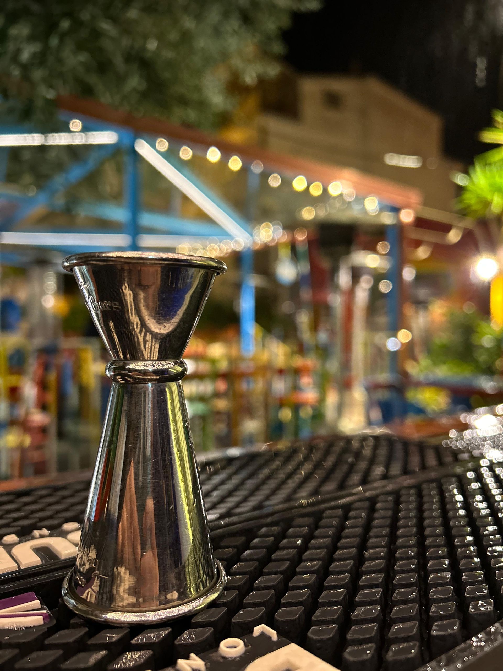 Una tazza graduata di metallo è appoggiata su un tavolo fuori di notte