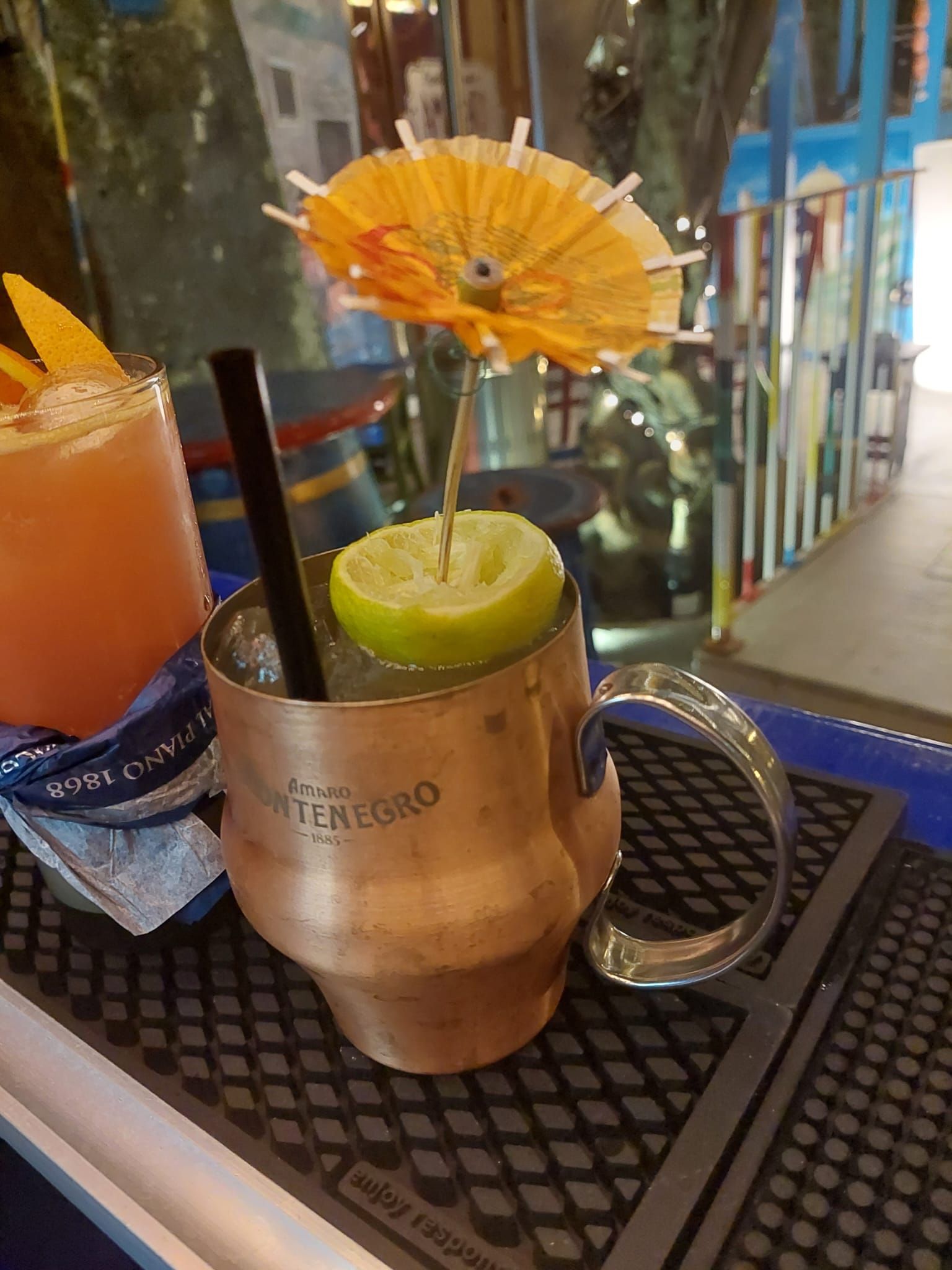 Una tazza di rame piena di una bevanda e una cannuccia su un bancone del bar.