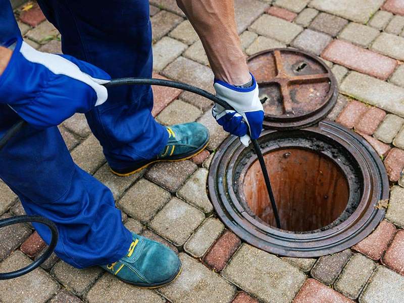 man cleaning a sewer