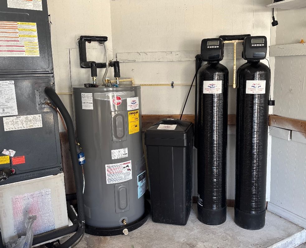 Water heater, black utility unit, and twin water softeners in a utility room.