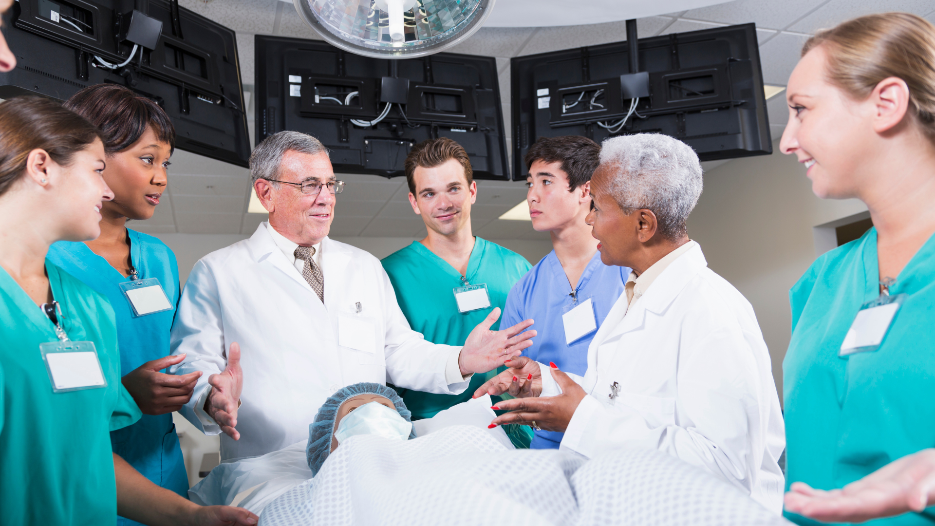 A group of doctors and nurses are talking to a patient in an operating room.