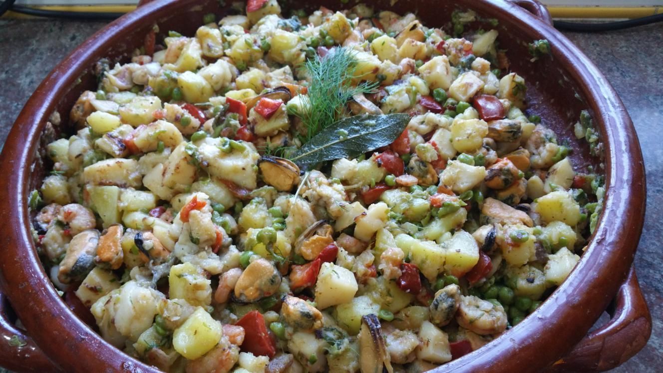 Un plato de comida con patatas y verduras en una mesa.
