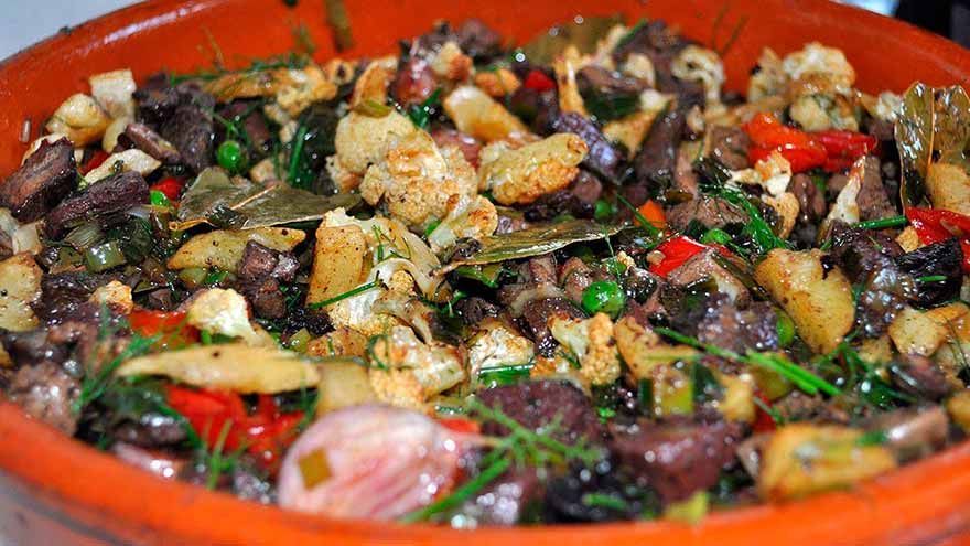 Un primer plano de un plato de comida con carne y verduras.