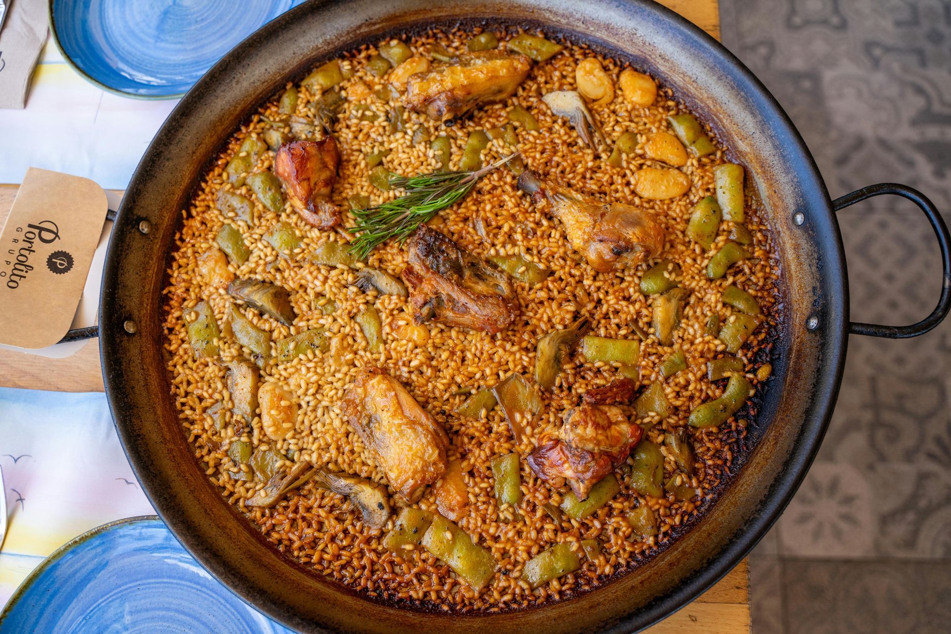 Una sartén llena de arroz y verduras está sobre una mesa.